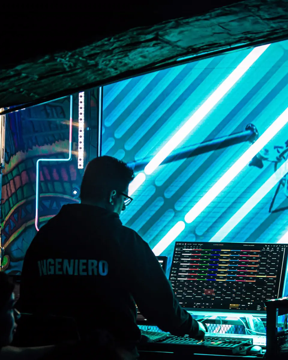 LUMEN de espaldas operando la consola de video frente a la pantalla LED de un show